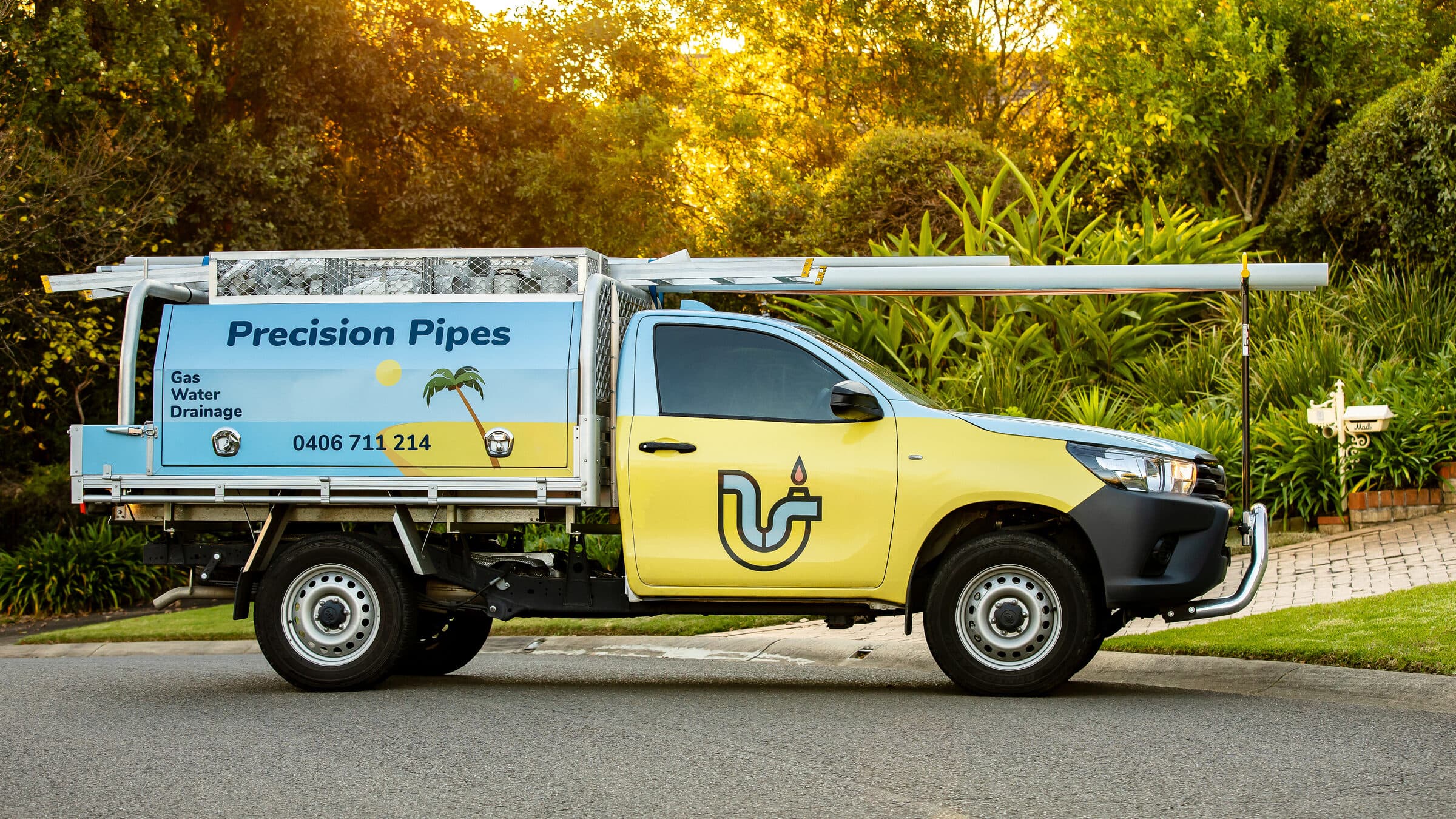 The signwritten Precision Pipes ute parked at the kerb of a Hills District street